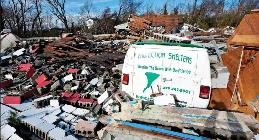  ?? ?? FORCE OF NATURE: Rescuers assess the damage after a train was blown off its tracks in Kentucky, top. Above: A pile of rubble – all that is left of these buildings in Kentucky – engulfs a van for a protection shelter firm. Left: The remains of an Amazon warehouse in Illinois