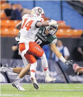  ?? MARCO GARCIA/ASSOCIATED PRESS ?? New Mexico safety Daniel Henry (14) defends against Hawaii wide receiver Makoa Camanse-Stevens during the first quarter of Saturday night’s game.