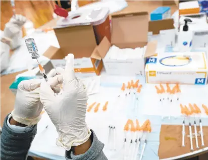  ?? MARY ALTAFFER/AP ?? A registered nurse fills a syringe with the Johnson & Johnson COVID-19 vaccine. The J&J vaccine, sometimes referred to as the one-and-done shot, has been considered a critical tool in upending the pandemic around the world because it only requires one injection rather than two.