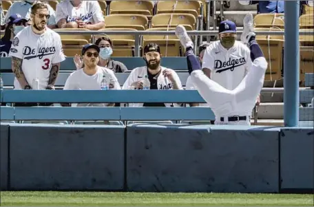  ?? Robert Gauthier Los Angeles Times ?? DODGERS right fielder Zach McKinstry takes a tumble over a wall at Dodger Stadium after trying to catch a foul ball hit by Andrew Stevenson of the Washington Nationals. Watching the play are some of the 15,036 socially distanced fans, the first there in 548 days.