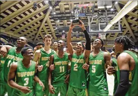  ?? PHOTOS BY HYOSUB SHIN / HSHIN@AJC.COM ?? Buford’s Bobby Miller holds the trophy as he celebrates with teammates after defeating Fayette County 76-69 in the AAAAA boys state final.