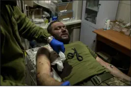  ?? NICOLE TUNG — THE NEW YORK TIMES ?? Doctors and medics treat a Ukrainian soldier who was wounded by shrapnel near Kreminna, Ukraine, on Thursday.