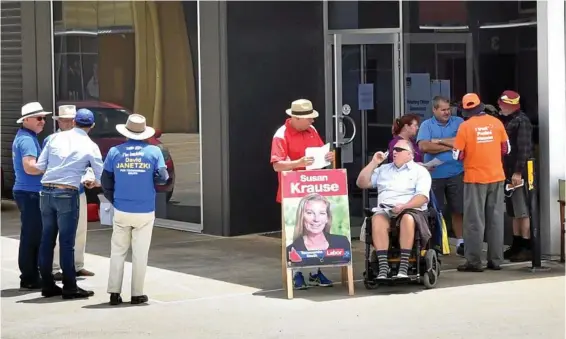  ??  ?? EARLY BALLOT: Supporters of the LNP, ALP and One Nation hand out how to vote cards at the Anzac Avenue pre-polling station. PHOTO: BEV LACEY