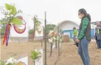  ?? TYLER PASCIAK LARIVIERE/ SUN-TIMES ?? Jeanette Uy pays her respects Wednesday at a memorial set up for Monty and Rose at Montrose Beach.