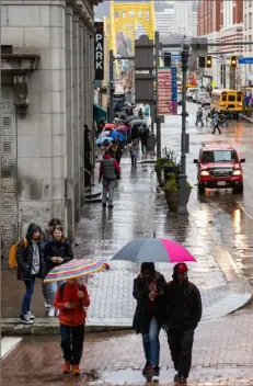  ?? Emily Matthews/Post-Gazette ?? A BIT OF A DAMPER Pedestrian­s walk in the rain across Ninth Street at the intersecti­on of Liberty Avenue, Downtown, on Tuesday.