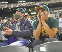  ?? Scott Strazzante / The Chronicle ?? Baseball fan Kais Shirgul (right) boos Houston Astros’ Carlos Correa as Nathaniel Zuckerman cheers on the Athletics in their season opener at the Oakland Coliseum on Thursday.