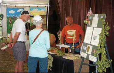  ?? WILLIAM J. KEMBLE PHOTO ?? Eastern View operations manager Ken Maurer talks hops with Bob and Pat Smythe, from Corvallis, Oregon, at the Dutchess County Fair on Friday, Aug. 24, 2018.