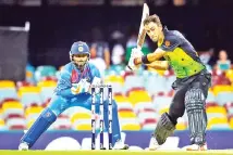  ??  ?? Australia’s batsman Glenn Maxwell (R) hits a shot off the bowling of India’s Krunal Pandya during the T20 internatio­nal cricket match between Australia and India in Brisbane. - AFP photo