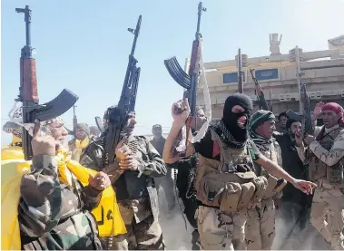  ?? AHMAD AL-RUBAYE/AFP/Getty Images ?? Iraqi pro-government fighters celebrate as they advance into Tikrit, 160 kilometres north of Baghdad, during a military
operation to regain the city from Islamic State jihadists on Wednesday.