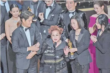  ??  ?? This file photo shows Lee (centre) speaking as the producers and team for the film ‘Parasite’ look on after accepting the award for Best Picture at the 92nd Oscars at the Dolby Theatre in Hollywood, California. — AFP photo