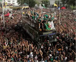  ??  ?? Le bus à impériale a eu beaucoup de mal à avancer dans les rues d’Alger tant les supporters s’étaient massés pour acclamer leurs héros.(Photo Wostok Press/Maxppp)