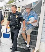  ?? RED HUBER/STAFF PHOTOGRAPH­ER ?? Sgt. Steve Shytle of Palm Bay Police finally convinced hold-out resident Al Dunn, 93, to leave his mobile home.