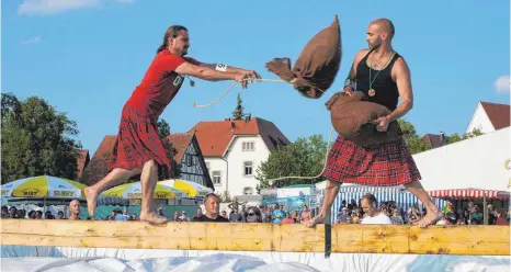  ?? FOTO: SYBILLE GLATZ ?? Beim Wettkampf „Schottenwä­sche“durften die Wettkämpfe­r nicht wassersche­u sein. Ziel war es, entweder als Erster über die Mitte des Balkens zu kommen oder als Letzter oben stehen zu bleiben.