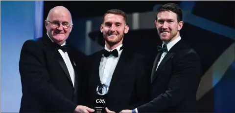  ??  ?? John is presented with his Champion 15 award by Uachtarán Cumann Lúthchleas Gael John Horan, left, and GPA Chairman Seamus Hickey.