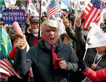  ?? GETTY IMAGES ?? A protester wears a Donald Trump mask during a rally in Seoul denouncing the South Korean government’s policies on North Korea. The Trump administra­tion is struggling to find a path forward with nuclear talks as tensions with North Korea mount.