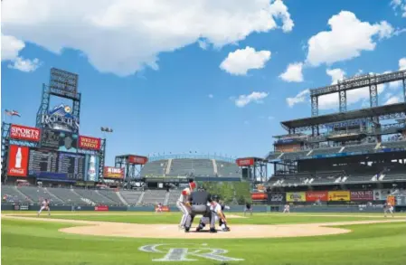  ??  ?? Tuesday’s first game of a split doublehead­er between the Arizona Diamondbac­ks and the Rockies was a makeup from a previously postponed game. Coors Field had many more empty seats than full ones. Jack Dempsey, The Associated Press