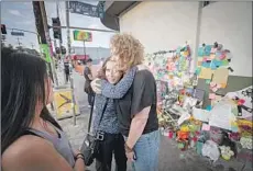  ?? Allen J. Schaben Los Angeles Times ?? MARYLINDA MOSS and Lynne Westafer, right, hug Tuesday outside Trader Joe’s in Silver Lake, where they were held hostage July 21.