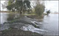  ?? BEA AHBECK/NEWS-SENTINEL ?? Above: A levee breached along the Mokelumne River near Thornton on Jan. 11. Right: About 5,000 cubic feet of water per second rushes through the gates at the Mokelumne River Fish Hatchery on Jan. 9.