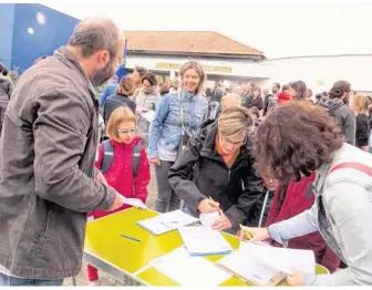  ??  ?? Lundi 4 septembre, jour de rentrée, Bertrand Chotard, à gauche, explique la situation aux parents et les invite à signer la pétition.