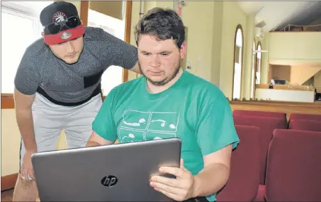  ?? ADAM MACINNIS/THE NEWS ?? Ben Dunnett, standing, and Jonathan Rogers go over plans for upcoming day camps at First Baptist Church in New Glasgow.