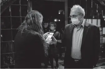  ?? Associated Press file photo ?? A man presents his “green passport,” proof that he is vaccinated Feb. 23 at the Khan Theater for a performanc­e where all guests were required to show proof of vaccinatio­n in Jerusalem.