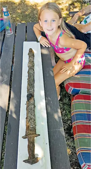  ??  ?? Eight-year-old Saga Vanecek with the sword she found while searching for stones to skim