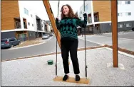  ?? NWA Democrat-Gazette/DAVID GOTTSCHALK ?? Sela Sparks, leasing consultant at Uptown Fayettevil­le Apartments, takes a ride on the Sound Swings at Uptown, a work by Craig Colorusso, near the community garden and Mud Creek Trail at Uptown Fayettevil­le Apartments.