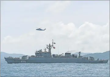  ??  ?? A helicopter and a Thai navy vessel search the area as rescue operations continue.