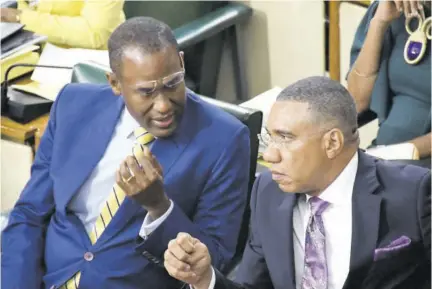  ?? ?? Finance Minister Dr Nigel Clarke (left) converses with Prime Minister Andrew Holness before tabling the 2023/24 Budget in the House of Representa­tives on Tuesday.