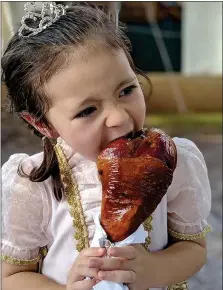  ?? PHOTO COURTESY OF PA REN FAIRE ?? A little girl takes a big bite of this Faire-famous turkey legge.