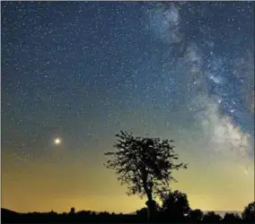  ?? PETER KOMKA— MTI VIA AP ?? In a picture issued on Mars, left, and the Milky Way are visible in the clear night sky as photograph­ed near Salgotarja­n, some 110kms northeast of Budapest, Hungary, Friday, late.