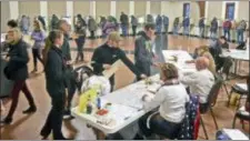  ?? TOM STROMME — THE BISMARCK TRIBUNE VIA AP ?? Voters line up to receive ballots while others fill voting booths inside the northwest Bismarck polling place in Century Baptist Church on Tuesday evening.