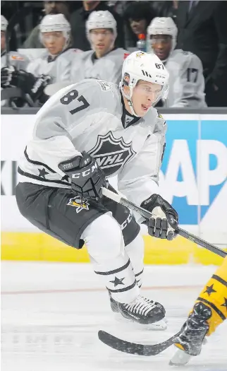  ?? BRUCE BENNETT/GETTY IMAGES ?? Metropolit­an captain Sidney Crosby carries the puck in an all-star tournament match against the Atlantic Division on Sunday in Los Angeles. Crosby scored his first all-star point in the game.