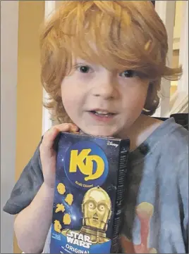  ?? Cp photo ?? Everett Botwright holds a package of Star Wars Kraft Dinner in Nanaimo, B. C., Hundreds of boxes of the limited- edition pasta now fill the family home following a plea to help their autistic son.