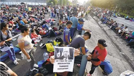  ?? EDGAR CLEMENTE AP ?? A migrant holds a photo of Mexican President Andrés Manuel López Obrador that reads, “The lives of migrants also matter,” as their caravan stops to block the highway in Huixtla, Mexico, Wednesday.