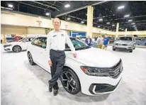  ??  ?? Rick Case leans on an unreleased Volkswagen model during the show at the Greater Fort Lauderdale/Broward County Convention Center.