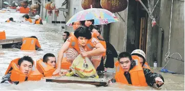  ??  ?? Rescuers evacuate residents through floodwater­s brought by typhoon Megi in Ningde, eastern China’s Fujian province. — AFP photo