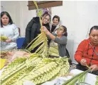  ?? GIOVANNA DELL’ORTO/AP ?? Isabel Tenorio, center, teaches how to weave palm fronds into elaborate designs in Minneapoli­s on Wednesday.