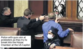  ??  ?? Police with guns aim at protesters as they try to break into the House Chamber at the US Capitol