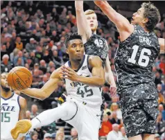  ?? Rick Bowmer ?? The Associated Press Jazz guard Donovan Mitchell prepares to pass against Spurs center Pau Gasol and forward Davis Bertans in the first half of Utah’s 101-99 win Monday at Vivint Smart Home Arena.