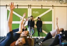  ?? MARY SCHWALM / ASSOCIATED PRESS ?? Fuel Training Studio owners Julie Bokat (left) and Jeanne Carter watch a fitness class inside their gym last month in Newburypor­t, Mass. Gyms and fitness studios were among the hardest hit businesses during the pandemic. But for gyms who made it through the worst, signs of stability are afoot.