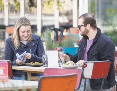  ?? Mary Altaffer / Associated Press ?? Emily Black and Adam Weinstein eat on May 20 on the patio of Mexicue restaurant in Stamford.