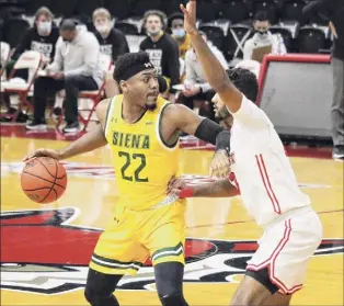  ?? Connor Giblin / Marist Athletics ?? Siena's Jalen Pickett looks to make a move against Marist during the Saints’ loss on Saturday. Pickett was 4-for-14 from the field and missed a last-second shot.