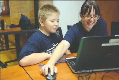  ?? NEWS-SENTINEL PHOTOGRAPH­S BY BEA AHBECK ?? Instructor Claire Bhakta, right, works with student Mason Lewis, 10, of Lodi, during the last day of the Code {STEAM} Tech Camp at the Lodi Public Library on Thursday.