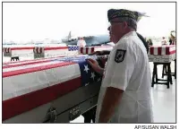  ?? AP/SUSAN WALSH ?? People pause at a case containing some of the remains Wednesday at a ceremony in Hawaii.