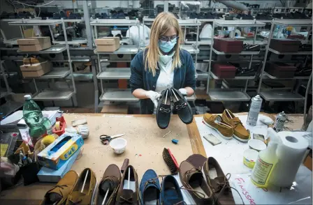  ?? DOMENICO STINELLIS /ASSOCIATED PRESS ?? Workers of the Calzaturif­icio M.G.T. shoe factory in Castelnuov­o Vomano, central Italy, return to work, May 4. Italy began stirring again Monday after a two-month coronaviru­s shutdown with 4.4million Italians able to return to work and restrictio­ns on movement eased.