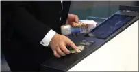  ?? KIYOSHI OTA — BLOOMBERG NEWS ?? A customer uses a rail commuter pass to purchase items at a cashierles­s kiosk powered by Signpost Corp. on a Tokyo train platform.