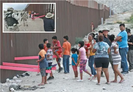  ?? Photos: AP ?? People line up to play on seesaws mounted on the US/Mexico border fence in Juarez, Mexico on July 28, 2019. INSET: Members of the Mexican military police wearing the insignia of the new National Guard check children and people as they play seesaw on July 28, 2019.