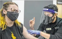  ?? L.E. Baskow Las Vegas Review-journal @Left_eye_images ?? Medical worker Jennifer Gorden, left, winces as Nevada State College School of Nursing student Edgar Ayala gives her a COVID-19 vaccinatio­n Friday in UNLV’S new clinic at CSN in Henderson.