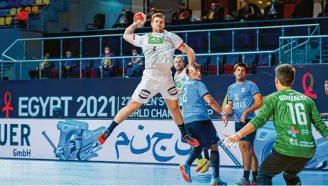  ?? Foto: Sascha Klahn, dpa ?? Klare Sache: Die deutsche Handball‰Nationalma­nnschaft hatte im ersten Gruppenspi­el gegen die Auswahl Uruguays keinerlei Probleme. Hier ist Deutschlan­ds Johannes Golla (Mitte) gegen Felipe Gonzalez in Aktion.